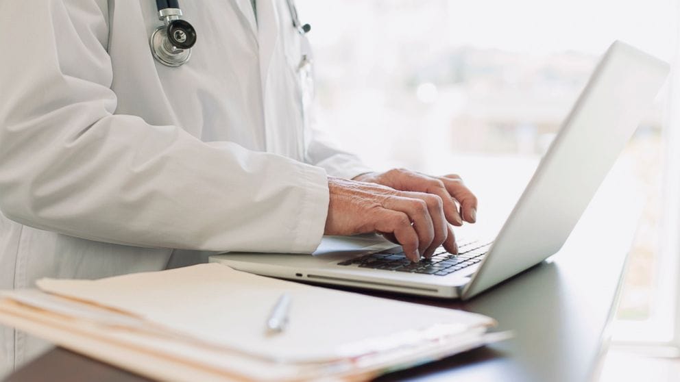 Dokter melakukan dokumentasi medis di komputer rumah sakit.