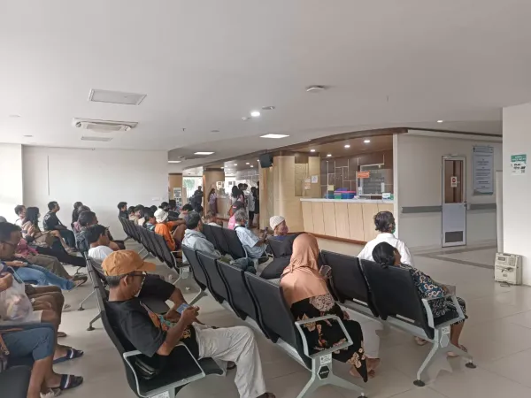 Ruang tunggu IGD rumah sakit tipe B di Indonesia dengan pasien menunggu pemeriksaan pada jam sibuk pagi hari.