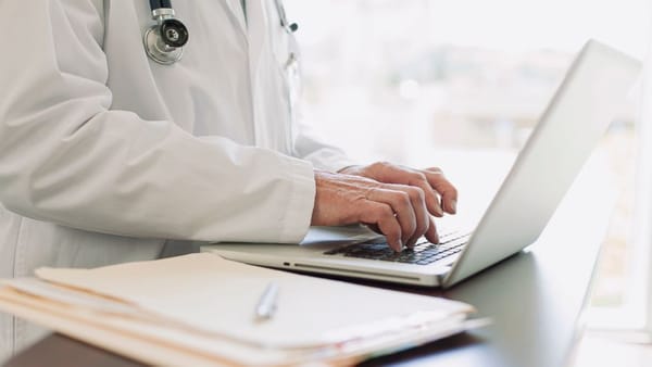 Dokter melakukan dokumentasi medis di komputer rumah sakit.