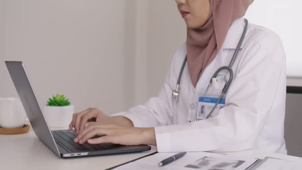 Tenaga kesehatan mendokumentasikan layanan di bangsal padat dengan RME; ilustrasi beban dokumentasi dan kebutuhan desain alur yang selaras dengan praktik klinis.